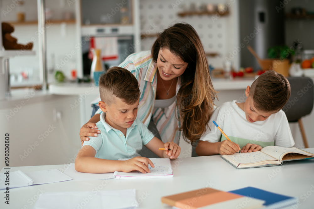 Mother helping her son with homework at home. Little boy learning at home.. Mother helping her son with homework at home. Little boy learning at home..