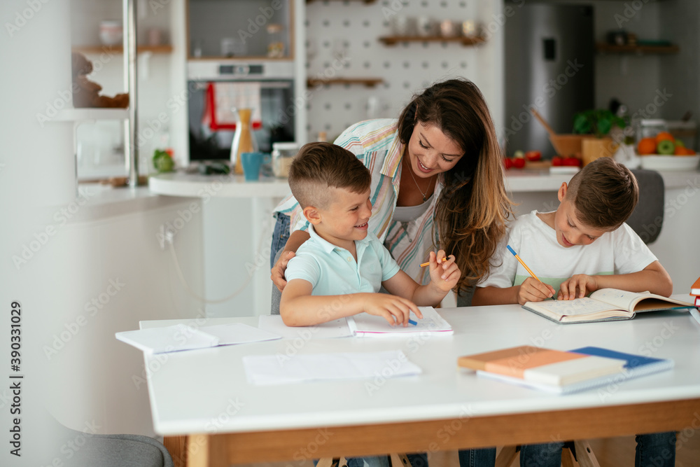 Mother helping her son with homework at home. Little boy learning at home.. Mother helping her son with homework at home. Little boy learning at home..