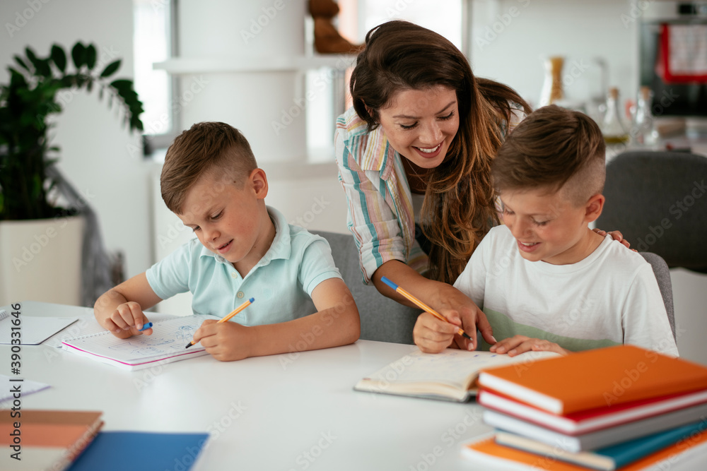 Mother helping her son with homework at home. Little boy learning at home.. Mother helping her son with homework at home. Little boy learning at home..