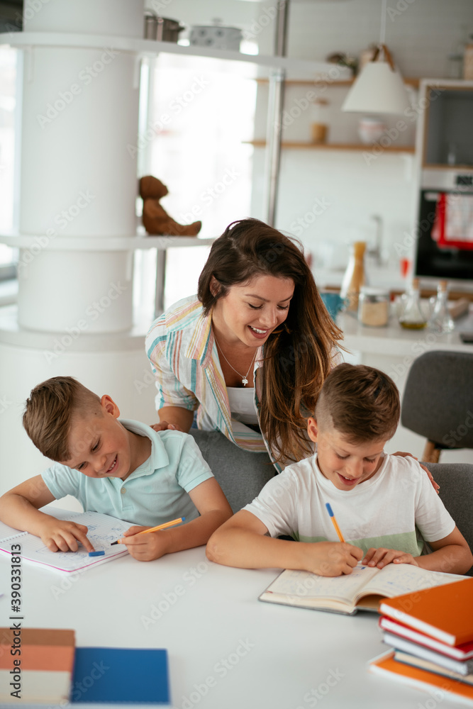 Mother helping her son with homework at home. Little boy learning at home.. Mother helping her son with homework at home. Little boy learning at home..