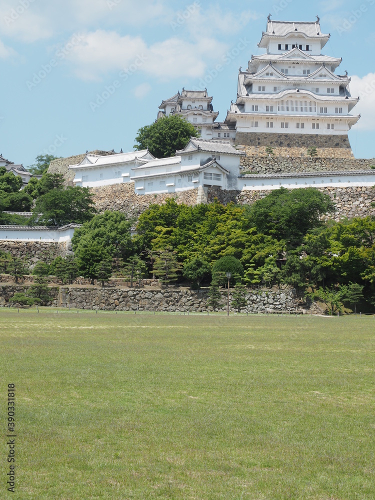 Ancient samurai castle in Himeji city in Japan with white walls, dark tile roofs and stone walls on a sunny day in summer with blue sky and white clouds Ancient samurai castle in Himeji city in Japan with white walls, dark tile roofs and stone walls on a sunny day in summer with blue sky and white clouds