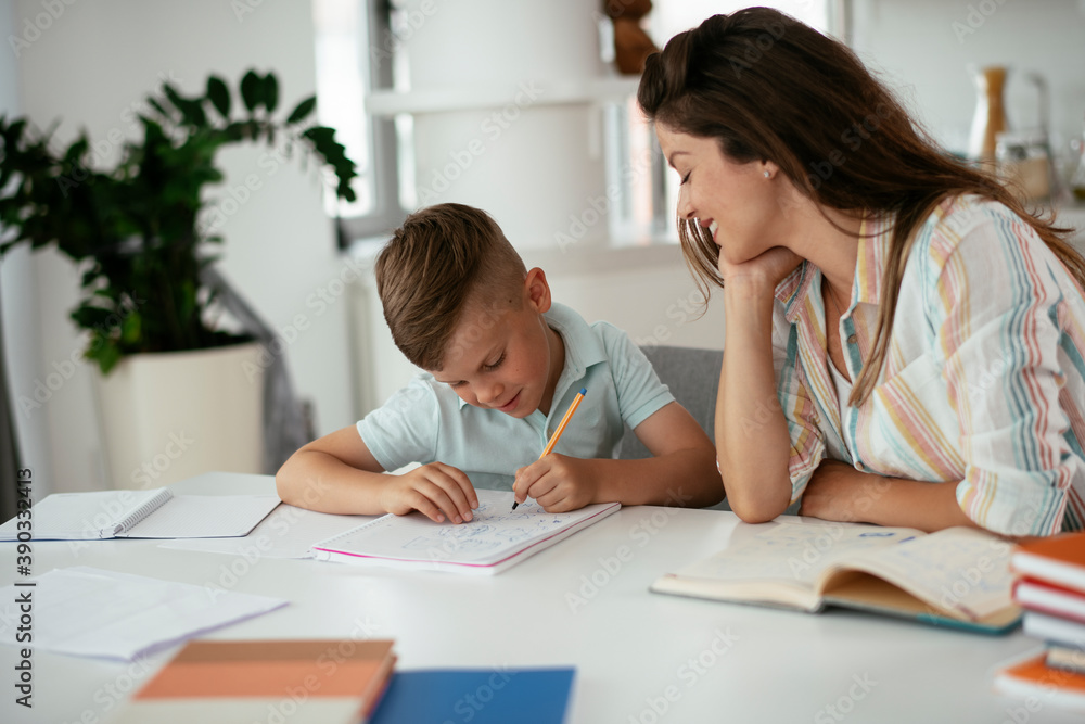 Mother helping her son with homework at home. Little boy learning at home.. Mother helping her son with homework at home. Little boy learning at home..