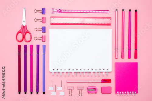 Pink notepad, pencil and marker on pink background. Flat lay. Concept office and back to school photo