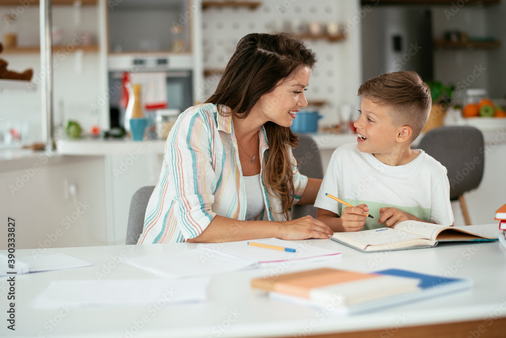 Mother helping her son with homework at home. Little boy learning at home.. Mother helping her son with homework at home. Little boy learning at home..