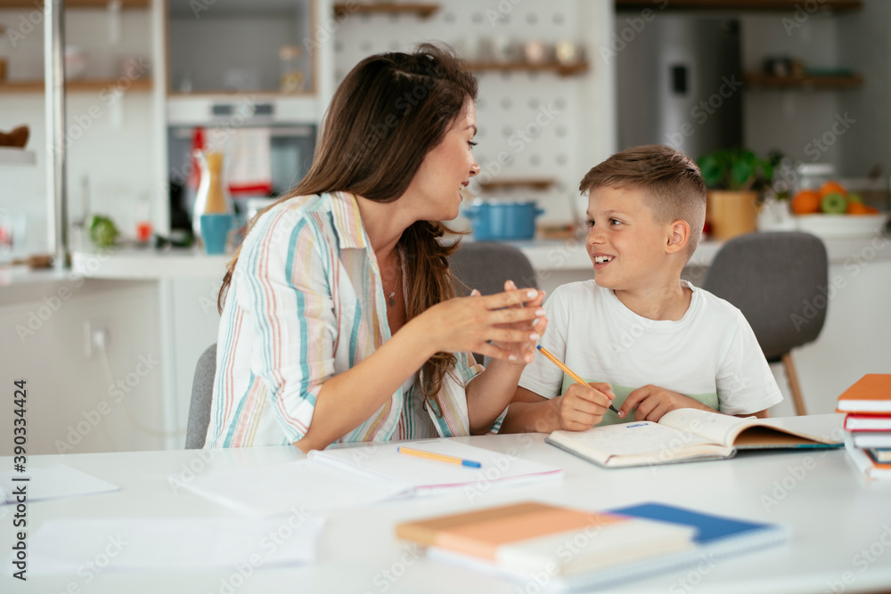 Mother helping her son with homework at home. Little boy learning at home.. Mother helping her son with homework at home. Little boy learning at home..
