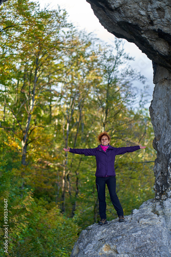 Woman hiker standing on the cliff in a doline