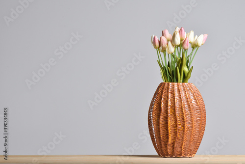Modern embossed ceramic vase with tulips on a gray background with a copy space