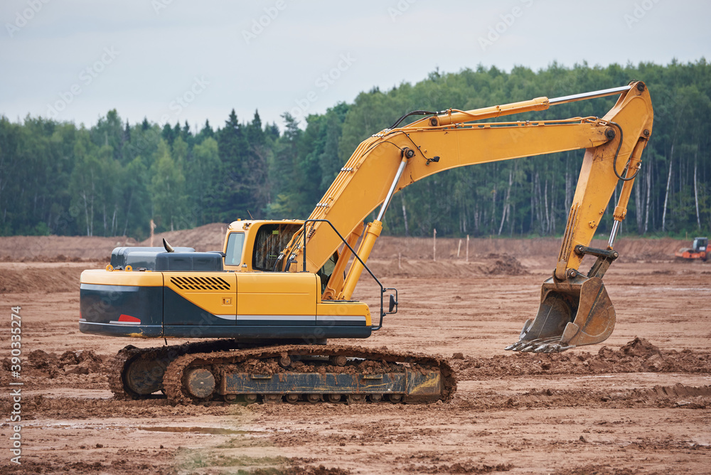 Modern crawler excavator drives through a muddy field Modern crawler excavator drives through a muddy field
