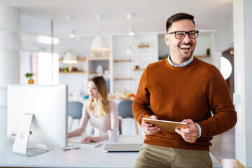 Handsome businessman using tablet in office. Technology, business, people concept.