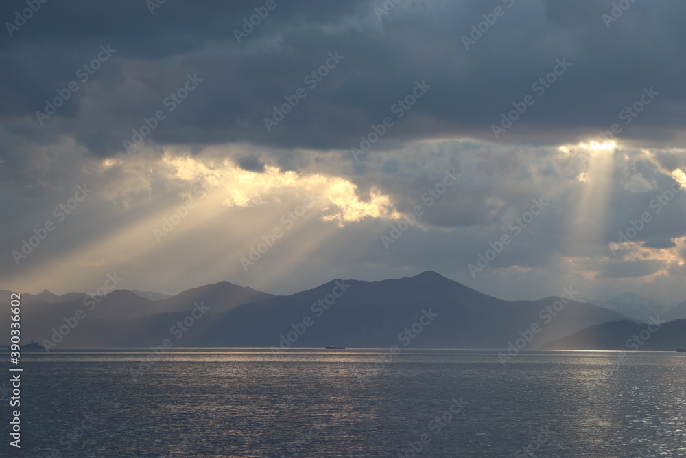 beautiful landscape. the sun hid the clouds. the rays of the sun fall on the water surface