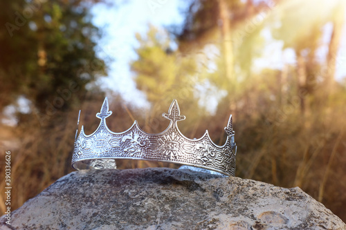 mysterious and magical photo of silver king crown in the England woods over stone. Medieval period concept.