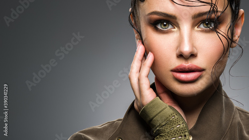 Closeup portrait of a beautiful young fashion woman with glamour makeup posing at studio.