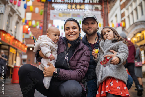 Photography Two happy parents and their two daughters posing in a blurry Chinatown alley