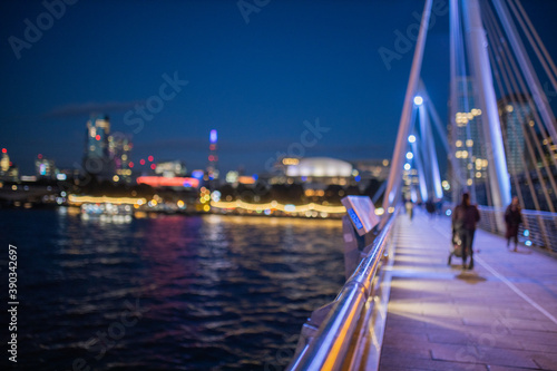 Cityscape at night from the handrail of a white bridge above the River Thames