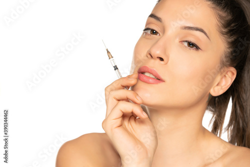 Portrait of a young beautiful woman posing with syringe