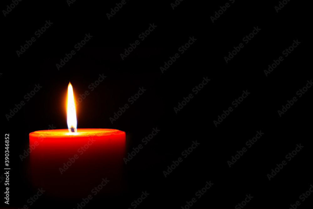 Burning red candle against dark background. Burning red candle against dark background.