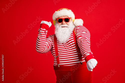 Portrait of his he handsome bearded fat overweight cheery Santa father fan meloman listening single melody dancing having fun rest chill isolated bright vivid shine vibrant red color background © deagreez