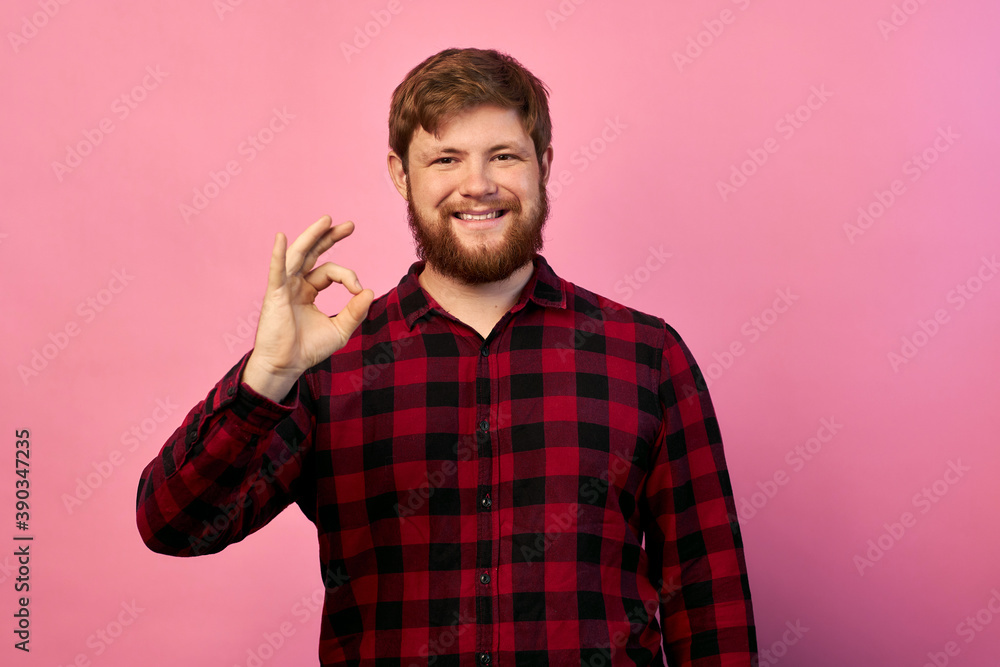 A young handsome man with a beard in a casual jacket relaxes and smiles, shows A young handsome man with a beard in a casual jacket relaxes and smiles, shows