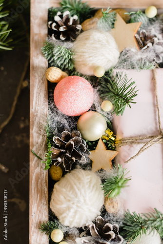 Christmas composition. Gift, Christmas pink decorations, cypress branches, pine cones in a box