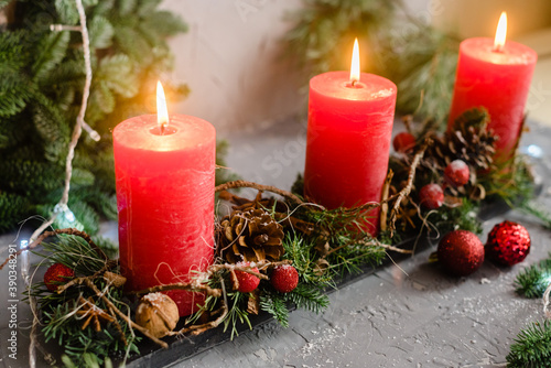 Christmas decoration composition with red candles, fir branches and balls