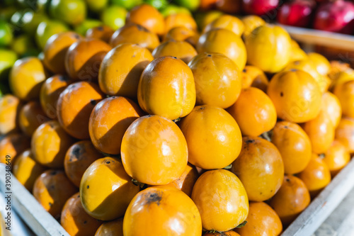 Ripe orange persimmon on the market counter