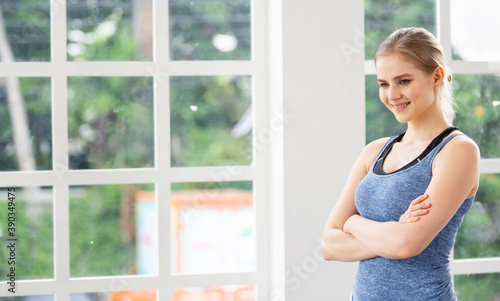 Portrait of Caucasian attractive woman in sportswear standing in arms crossed and smile in fitness studio. copy space