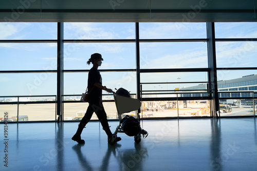 asian woman female air traveler walking in airport terminal building