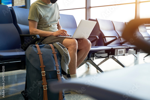 Photography asian man male air traveler sitting in airport waiting area using laptop compute