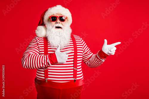 Portrait of his he nice handsome attractive glad cheerful bearded fat gray-haired Santa demonstrating copy empty blank place space isolated on bright vivid shine vibrant red color background © deagreez