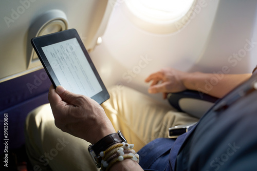 asian man male air traveler reading ebook on flight