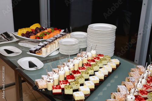 Plates with cookies, cakes and fruit on a buffet table. Selective focus.