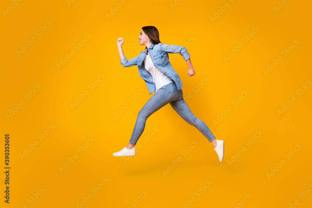 Full length body size profile side view of her she nice slim cheerful cheery girl jumping running fast speed active lifestyle regime isolated bright vivid shine vibrant yellow color background