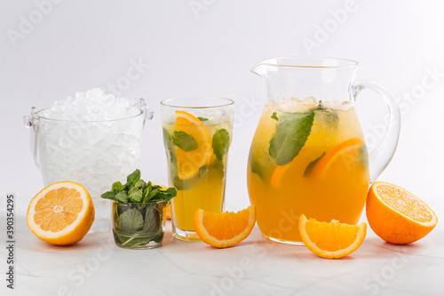 Orange and mint lemonade in a jug and glass