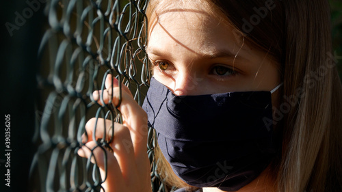 Sad Girl Wears Protective Mask due Coronavirus Pandemic, Sick Unhappy Child, Depressed Kid not Playing with Children, Depression