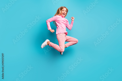 Full size photo of cool amazed pretty teen girl jump air wear pink pants poloneck white footwear isolated on bright teal background