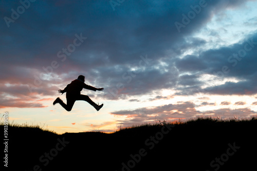 silhouette of a fast running man against the sunset, blurred silhouette in motion