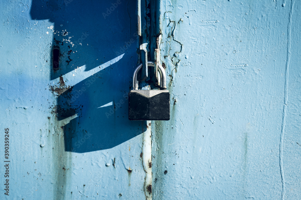 Old padlock on a blue door. Close up Old padlock on a blue door. Close up