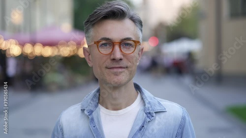 Close-up portrait of man standing at the street and looking at the camera.