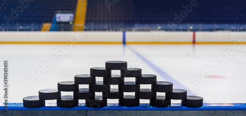 A pyramid made of ice hockey pucks stands on the sides of the ice arena. Hockey players' training will begin soon.