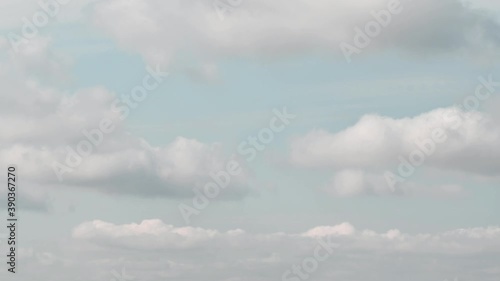 Time lapse of azure blue sky with white fluffy clouds floating in wind. Serene cloudscape of summer weather