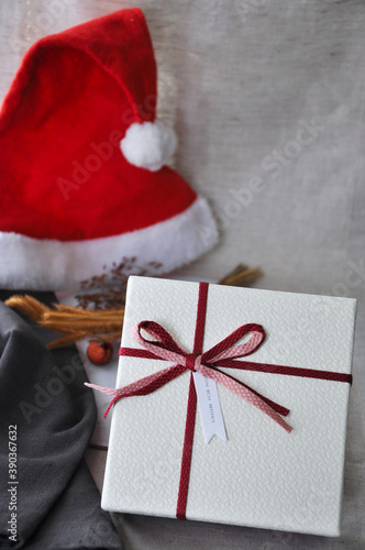 Greeting Season Concept Close up Gift Box and Red Santa on Background