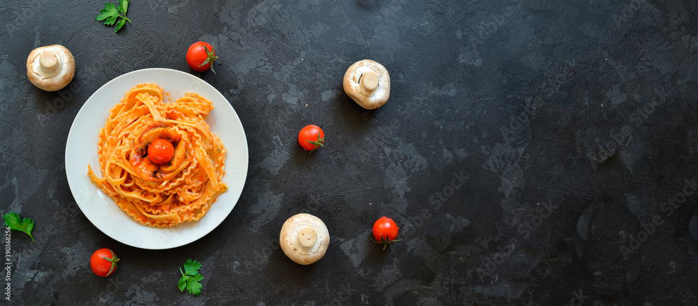 Pasta in a white plate. Pasta with tomato sauce, mushrooms with cherry tomatoes. Dark background. View from above. Free space for text. Copyspace