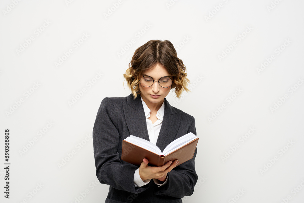Woman at work with book in hand light background classic suit glasses head Woman at work with book in hand light background classic suit glasses head