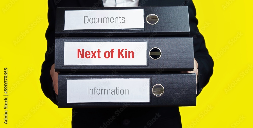 Next of Kin. Man carries stack of folders. File folders with text label ...