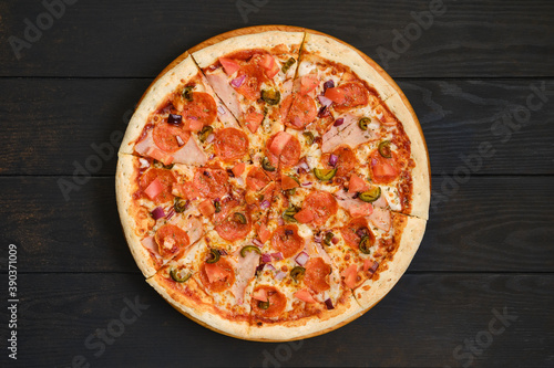 Pizza with pepperoni, ham, bell pepper, olives and red onion