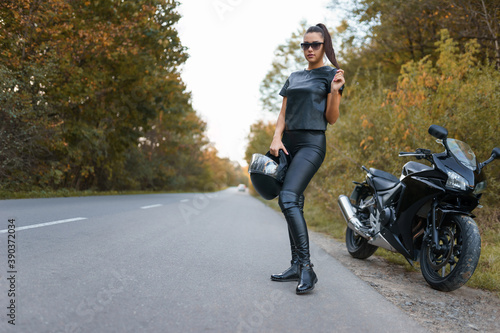 Stylish female motorcyclist on the road