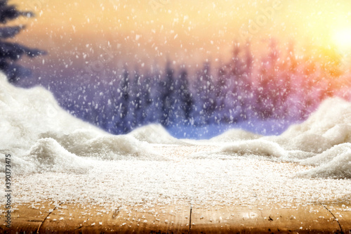 Beautiful winter landscape and snow on a wooden table with an atmospheric sunset.