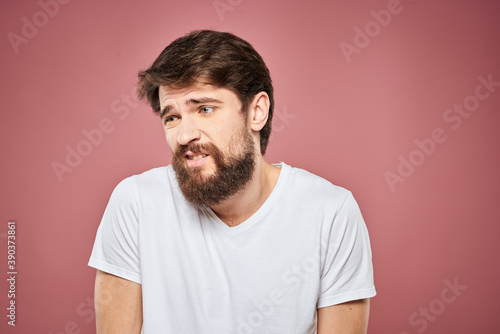 emotional man white t shirt sad facial expression pink background