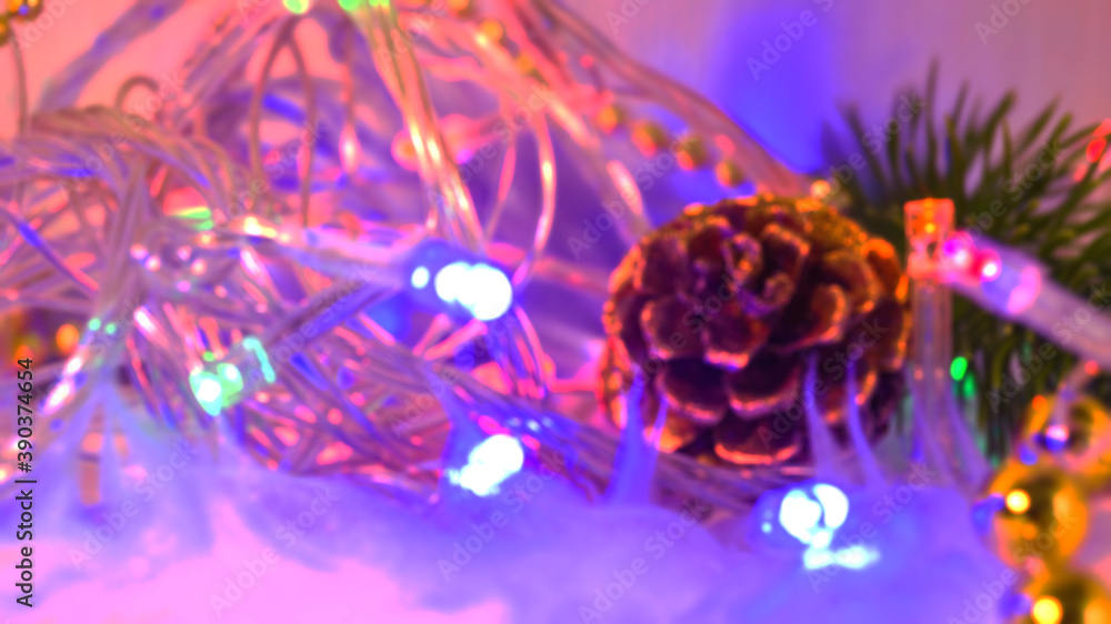 Blurred pine cone and branch and garland with colorful bright lights. Good New Year spirit. Blank for a postcard. Christmas and New Year. Place for text. Blurred pine cone and branch and garland with colorful bright lights. Good New Year spirit. Blank for a postcard. Christmas and New Year. Place for text.