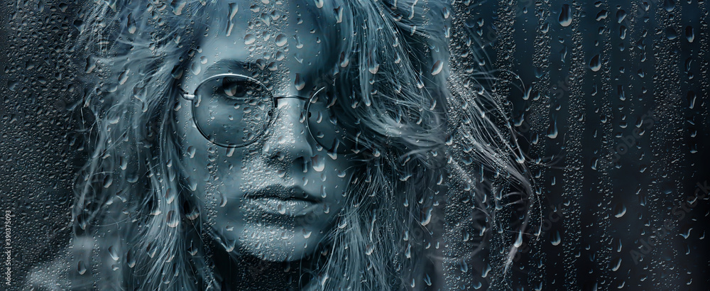 seasonal autumn pornetret, sad girl behind wet glass, raindrops background